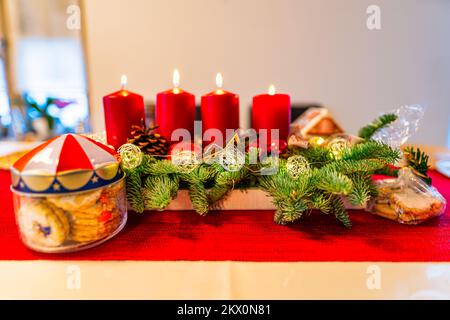 Décoration de Noël avec des biscuits et quatre bougies allumées sur une couronne d'advents de lovley. Banque D'Images