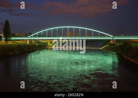 23.08.2017., Zagreb, Croatie - le pont ferroviaire vert sur la rivière Sava, grâce au graffiti avec le nom de Jimi Hendrix, a reçu un statut presque culte et est devenu l'un des symboles de la culture pop urbaine de Zagreb et il est appelé pont Hendrix. Il a été récemment décoré avec l'éclairage soulignant les contours de la partie inférieure du pont sur toute la longueur du faisceau principal (310m) et la structure supérieure du pont avec lumière statique, neutre blanc, tandis que l'éclairage de couleur dynamique s'active en passant le train avec le premier wagon derrière la locomotive . Photo: Davor Pukla Banque D'Images