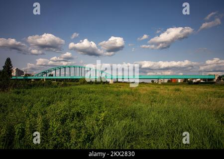 21.08.2017., Zagreb, Croatie - le pont ferroviaire vert sur la rivière Sava, grâce au graffiti avec le nom de Jimi Hendrix, a reçu un statut presque culte et est devenu l'un des symboles de la culture pop urbaine de Zagreb et il est appelé pont Hendrix. Il a été récemment décoré avec l'éclairage soulignant les contours de la partie inférieure du pont sur toute la longueur du faisceau principal (310m) et la structure supérieure du pont avec lumière statique, neutre blanc, tandis que l'éclairage de couleur dynamique s'active en passant le train avec le premier wagon derrière la locomotive . Photo: Davor Pukla Banque D'Images