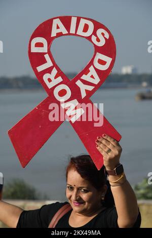 Kolkata, Inde. 30th novembre 2022. Un volontaire tient la bande rouge pendant la campagne de prévention contre le sida sur la rive du Gange avant la Journée mondiale du sida. (Photo de Biswarup Ganguly/Pacific Press) crédit: Pacific Press Media production Corp./Alay Live News Banque D'Images