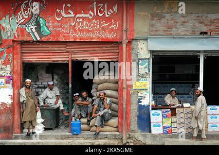 Landi Kotal, Khyber Pass, Khyber Pakhtunkhwa / Pakistan: Des hommes musulmans locaux à l'extérieur de deux magasins à Landi Kotal, Pakistan. Banque D'Images