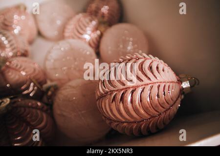 Fond vintage avec beaucoup de jouets en verre rose pâle avec paillettes pour arbre de Noël. Décor festif pour la fête du nouvel an 2023. Vacances d'hiver, se Banque D'Images