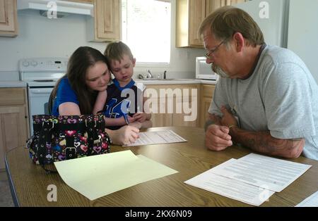 Inondations glissements de terrain/glissements de terrain tempête violente - Taylorville, W. , 24 juin 2009 Spécialiste en logement de la FEMA Randy Edwards (R) aide une candidate en logement communautaire et son fils à travailler sur papier pour être le premier locataire dans un nouveau site de logement communautaire ouvert à Taylorville. Louis Sohn/FEMA. Virginie-Occidentale : tempêtes, inondations, glissements de terrain et glissements de terrain. Photographies relatives aux programmes, aux activités et aux fonctionnaires de gestion des catastrophes et des situations d'urgence Banque D'Images