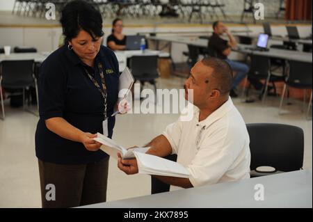 Tsunami du tremblement de terre - Utulei, Samoa américaines, Gabriela Garibaldi, directrice du Centre de reprise après sinistre de la FEMA de 8 octobre 2009, explique le processus de remboursement des funérailles à un candidat. Le Programme des particuliers et des ménages de la FEMA peut fournir de l'aide pour les frais funéraires directement liés à la catastrophe. David Gonzalez/FEMA. Tremblement de terre, tsunami et inondations aux Samoa américaines. Photographies relatives aux programmes, aux activités et aux fonctionnaires de gestion des catastrophes et des situations d'urgence Banque D'Images