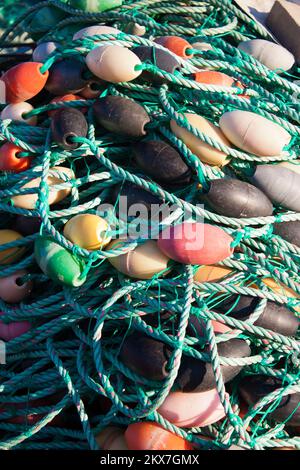 Cordes en nylon avec bouées de filets de pêche dans un tas sur le front de mer du port de pêche Banque D'Images