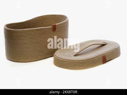 Panier en osier avec couvercle en jute sur fond blanc isolé Banque D'Images