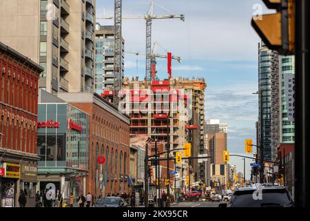 Ottawa, Canada - 5 novembre 2022 : rue Rideau au centre-ville d'Ottawa, Canada. Paysage urbain avec des chantiers de construction, des grues, de la circulation et des personnes marchant. Banque D'Images
