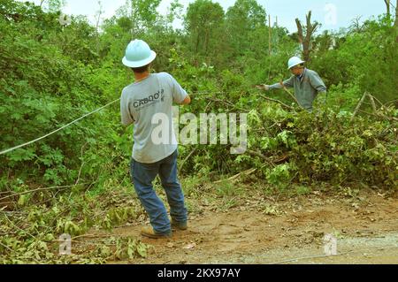 Tempête violente Tornado - Comté de Pottawatomie, Okla. , 13 mai 2010 deux membres d'un équipage de ligne coopérative électrique de Caddo aident à étrangler des lignes électriques à travers la brosse lourde dans un terrain accidenté, la restauration du service à un quartier laissé sans pouvoir par un chapeau de tornade frappé la région sur 10 mai. Le service électrique a été interrompu dans de nombreuses régions touchées par 22 tornades confirmées qui ont balayé la moitié est de l'État. FEMA . Tempêtes de l'Oklahoma, tornades et vents de la ligne droite. Photographies relatives aux programmes, aux activités et aux fonctionnaires de gestion des catastrophes et des situations d'urgence Banque D'Images