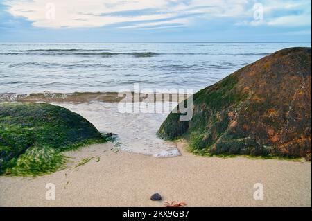 Grande pierre sur la plage de sable en face de la mer avec des nuages dans le ciel. Danemark en Scandinavie. Paysage tiré de la nature dans le nord Banque D'Images