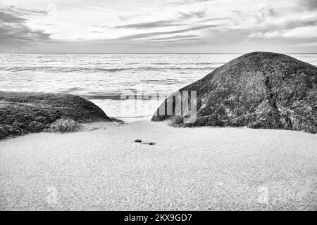 Grande pierre sur la plage de sable en face de la mer avec des nuages dans le ciel. Danemark en Scandinavie. Paysage tiré de la nature dans le nord Banque D'Images