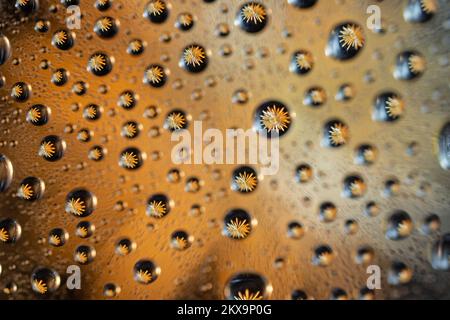 Une étoile dorée vue par des gouttes d'eau, une photographie de macro-motif avec effet de flou Banque D'Images