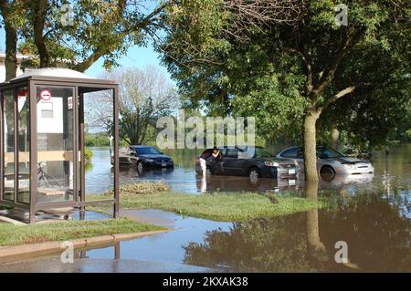 Inondations - Ames, Iowa, 11 août 2010 un résident d'Ames vérifie les effets personnels à la suite d'une chute de pluie record et d'une inondation dans la ville. Une coupure d'eau principale causée par l'inondation exigera des survivants du déluge de faire bouillir l'eau pendant les jours à venir. Jace Anderson/FEMA. Tempêtes, inondations et tornades de l'Iowa. Photographies relatives aux programmes, aux activités et aux fonctionnaires de gestion des catastrophes et des situations d'urgence Banque D'Images