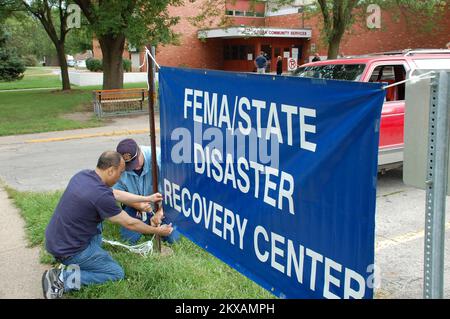 Inondations - des Moines, Iowa, les spécialistes de la logistique de 24 août 2010 Orlando Alvarez (à gauche) et Rusty Clarke ont présenté un panneau annonçant l'ouverture d'un centre de reprise après sinistre à des Moines, Iowa. Les RDC tels que ces derniers hébergent des employés d'assistance fédéraux et d'État pour aider les Iowans à se remettre de la récente inondation à partir de juin. Jace Anderson/FEMA. Tempêtes, inondations et tornades de l'Iowa. Photographies relatives aux programmes, aux activités et aux fonctionnaires de gestion des catastrophes et des situations d'urgence Banque D'Images