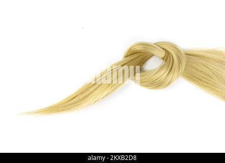 Mèche de cheveux blond nouée sur fond blanc. Brin de cheveux soyeux blonds sur fond blanc Banque D'Images
