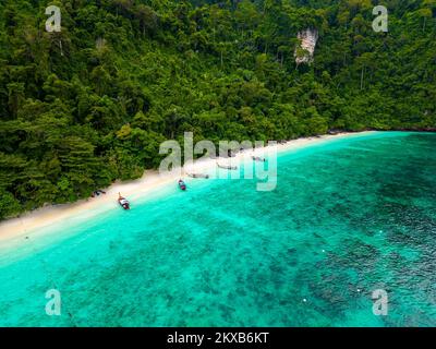 Vue aérienne de drone sur la célèbre plage de Monkey Beach sur l'île de Ko Phi Phi, en Thaïlande. Plage tropicale avec sable blanc, eau turquoise et forêt verte. Queue longue Banque D'Images