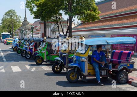 Bangkok, Thaïlande - 19 mars 2018 : un pousse-pousse automatique assis dans son véhicule à l'avant d'une rangée de tuk tuk qui attendent les clients. Banque D'Images