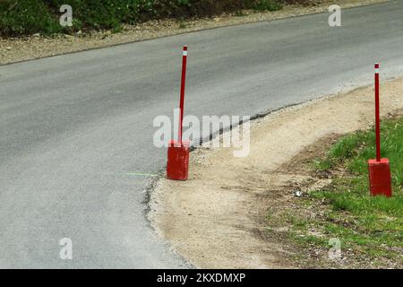 La photo de la partie de la route utilisée pour l'événement de rallye. Une tige anti-coupure avec un bloc de béton se trouve à l'intérieur de la courbe. Banque D'Images