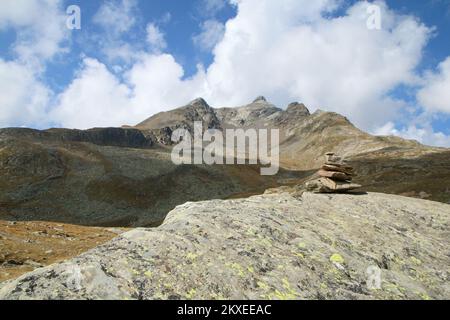 Vue panoramique sur les Alpes italiennes au sommet de Passo di Gavia. De beaux sommets et un lac en dessous pendant la journée ensoleillée. Banque D'Images