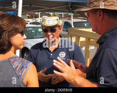 Tornado - Tuscaloosa, Alabama , 18 juillet 2011 Disaster survivior Jennifer Wilson écoute les spécialistes de l'atténuation de la FEMA Rick Burgess (parle) et David Curbelo expliquent l'importance des salles de sécurité lors d'un atelier de sensibilisation à l'atténuation de la FEMA organisé par WTXT et ZBQ radio devant Starbucks, Midtown Village Mall, 1800 McFarland Blvd. , Tuscaloosa. Alabama : fortes tempêtes, tornades, vents en ligne droite et inondations. Photographies relatives aux programmes, aux activités et aux fonctionnaires de gestion des catastrophes et des situations d'urgence Banque D'Images
