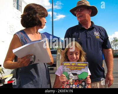 Tornado - Tuscaloosa, Alabama , 18 juillet 2011 Rick Burgess, spécialiste de l'atténuation de la FEMA, s'adresse à Jennifer Wilson, survivante d'une catastrophe de Tuscaloosa, lors d'un atelier de sensibilisation à l'atténuation de la FEMA organisé par WTXT et ZBQ radio devant Starbucks, centre commercial de Midtown Village, 1800, boul. McFarland. , Tuscaloosa. Kathryn Wilson lit « Ready... » de la FEMA. Définir... Préparé » pendant que sa mère et Rick Burgess de la FEMA discutent de l'importance des salles de sécurité. Inondations dans le Dakota du Nord. Photographies relatives aux programmes, aux activités et aux fonctionnaires de gestion des catastrophes et des situations d'urgence Banque D'Images
