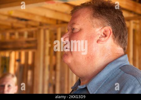 Tornado - Tuscaloosa, Alabama , 2 août 2011 Habitat pour l'humanité de Tuscaloosa le directeur exécutif Bob Johnson vérifie les travaux en cours à Tuscaloosa que les bénévoles d'Habitat travaillent dans la chaleur à 100 degrés pour reconstruire des maisons sur 5th rue après que de nombreuses maisons ont été détruites par une série de tornades qui ont frappé l'Alabama sur 27 avril. La FEMA soutient la générosité et l'expertise d'organismes bénévoles (VOLAGS) comme Habitat pour l'humanité. La FEMA tente de coordonner les efforts de rétablissement de l'agence par le biais de ses spécialistes de la liaison avec le VOLAG. Photographies relatives aux programmes de gestion des catastrophes et des urgences, Activi Banque D'Images