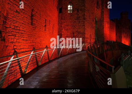 Caernarfon Castle, illuminé en rouge pour commémorer l'équipe de football du pays de Galles, coupe du monde 2022, Gwynedd, pays de Galles du Nord, Royaume-Uni, Banque D'Images