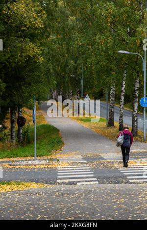 Femme non reconnue marchant à l'extérieur dans la rue en automne. Saison d'automne. Personnes actives. Banque D'Images