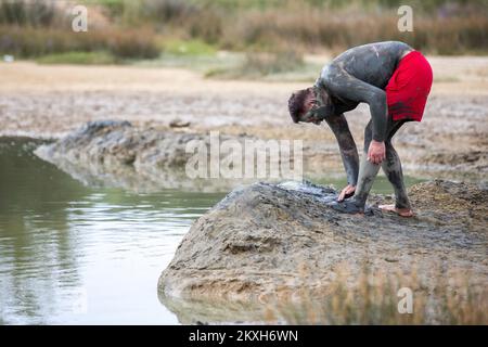 Les gens ont couvert de boue à la plage dans un petit endroit de la Meline, île Krk, Croatie, 14 août,2020. Du début du printemps à la fin de l'automne, la plage du village de Melina est l'une des plus visitées de l'île grâce à la boue curative qui couvre la plage. Les bénéfices de la boue ont été reconnus par beaucoup, en particulier les patients atteints de polyarthrite rhumatoïde qui, après s'être enveloppés de boue, se sentent un grand soulagement.photo: Nel Pavletic/PIXSELL Banque D'Images