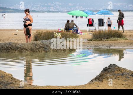 Les gens ont couvert de boue à la plage dans un petit endroit de la Meline, île Krk, Croatie, 14 août,2020. Du début du printemps à la fin de l'automne, la plage du village de Melina est l'une des plus visitées de l'île grâce à la boue curative qui couvre la plage. Les bénéfices de la boue ont été reconnus par beaucoup, en particulier les patients atteints de polyarthrite rhumatoïde qui, après s'être enveloppés de boue, se sentent un grand soulagement.photo: Nel Pavletic/PIXSELL Banque D'Images