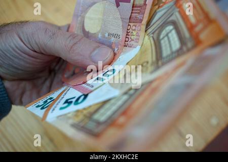 euro notes dans ma main gauche prêt à dépenser en raison de l'inflation Banque D'Images