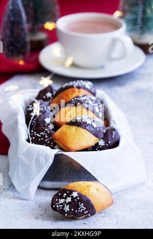 Petits gâteaux traditionnels de la madeleine française servis avec café, décoration de Noël. Banque D'Images
