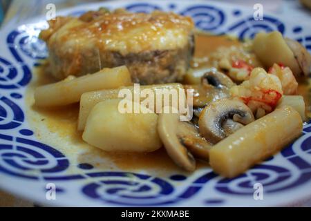 hake aux asperges et aux champignons dans un beau plat Banque D'Images