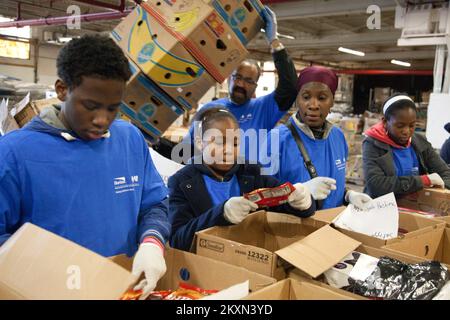 Ouragan d'inondation/tempête tropicale - Hillside, N. J. , 5 novembre 2011 Tawfeeg Bashiru (à gauche), Safiyyah Bashiru (au centre), et leur mère Ayesha Bashiru (à droite), bénévoles de la famille de Horizon Blue Cross Blue Shield of New Jersey, aident à trier et à emballer les dons alimentaires à la Banque alimentaire communautaire du New Jersey. Ouragan Irene du New Jersey. Photographies relatives aux programmes, aux activités et aux fonctionnaires de gestion des catastrophes et des situations d'urgence Banque D'Images