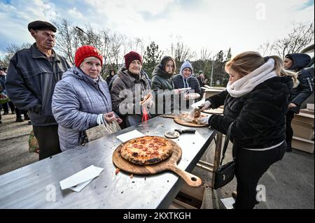 ZAPORIZHIA, UKRAINE - le 30 NOVEMBRE 2022 - les personnes déplacées par la guerre de la Russie contre l'Ukraine font la queue pour des pizzas gratuites cuites par des volontaires étrangers, Zapor Banque D'Images