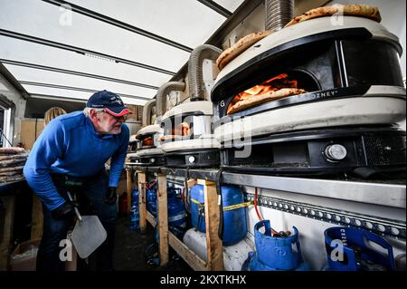 ZAPORIZHHIA, UKRAINE - 30 NOVEMBRE 2022 - Un volontaire étranger s'occupe des fours car des pizzas gratuites sont cuites pour les personnes déplacées par la Russie Banque D'Images