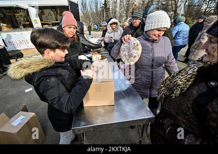 ZAPORIZHIA, UKRAINE - le 30 NOVEMBRE 2022 - les personnes déplacées par la guerre de la Russie contre l'Ukraine font la queue pour des pizzas gratuites cuites par des volontaires étrangers, Zapor Banque D'Images