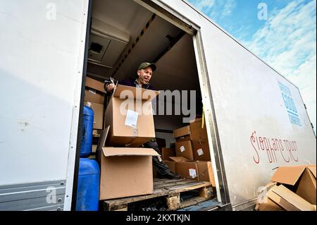 ZAPORIZHHIA, UKRAINE - 30 NOVEMBRE 2022 - Un homme décharge les boîtes avec des ensembles de pizza comme volontaires étrangers sont à faire cuire pour les personnes déplacées par Banque D'Images