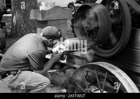 Hommes travaillant sur des équipements de ferme à vapeur anciens à la foire de Hopkinton. Hopkinton, New Hampshire. L'image a été capturée sur film analogique noir et blanc. Banque D'Images