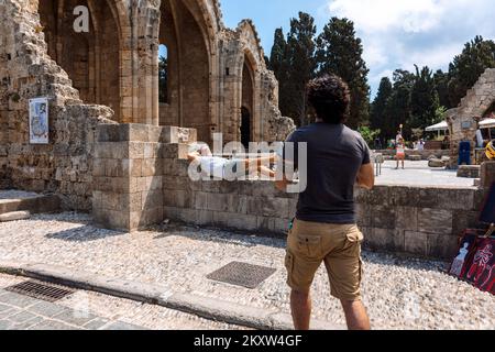 Rhodes, Grèce - 23 août 2022 : ruelles pavées et historiques de Rhodes. Les touristes marchent sur la vieille ville, Rhodes, Dodécanèse, Grèce. Banque D'Images