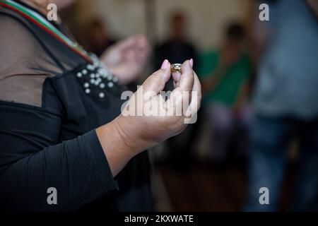 Fonctionnaire du mariage tenant les deux anneaux de mariage dans ses mains devant le couple, les bénédiction. Photo de haute qualité Banque D'Images