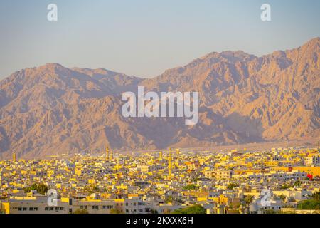 Vue sur les toits d'Aqaba en Jordanie jusqu'aux collines derrière au coucher du soleil Banque D'Images