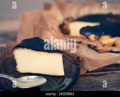 Morceau de cheesecake basque maison brûlé, foyer sélectif. Parfaitement brûlé sur l'extérieur et crémeux dans le gâteau espagnol moyen Banque D'Images