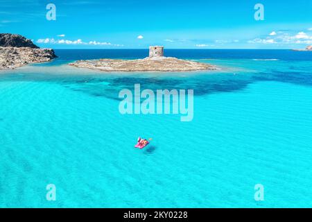 Vue de dessus de magnifique paysage marin. Vue aérienne du groupe de personnes flotte sur un catamaran dans l'eau bleu clair Banque D'Images