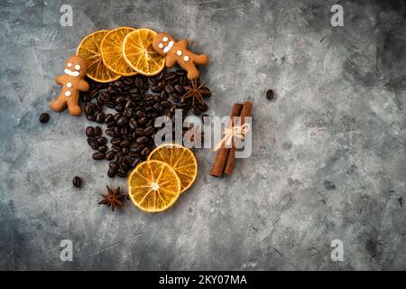 Composition de Noël avec grains de café, tranches d'oranges séchées, biscuits et bâton de cannelle sur fond texturé gris. Plan de pose plat du dessus avec Banque D'Images