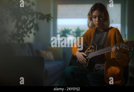 Adolescente apprenant à jouer de la guitare semi-acoustique. Banque D'Images