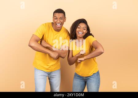 Portarit de joyeux couple afro-américain dansant et se moquant autour, s'amusant et appréciant la musique préférée Banque D'Images