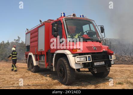 Feu dans une zone ouverte près du site archéologique Velika Mrdakovica dans l'arrière-pays de Vodice, en Croatie, sur 13 juillet 2022. Environ 30 pompiers et une douzaine de véhicules sont au sol, et deux Canadairs se sont joints aux forces terrestres pour éteindre l'incendie. Il y a des forêts de pins au-dessus, une faible végétation et des bâtiments en danger. Photo: Dusko Jaramaz/PIXSELL Banque D'Images