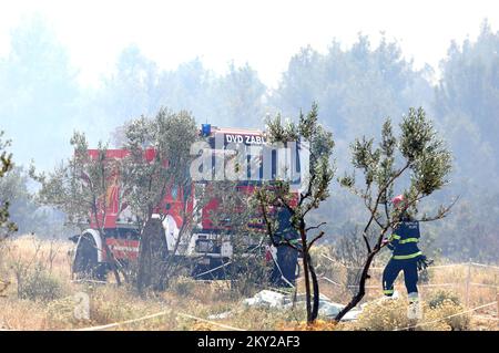 Feu dans une zone ouverte près du site archéologique Velika Mrdakovica dans l'arrière-pays de Vodice, en Croatie, sur 13 juillet 2022. Environ 30 pompiers et une douzaine de véhicules sont au sol, et deux Canadairs se sont joints aux forces terrestres pour éteindre l'incendie. Il y a des forêts de pins au-dessus, une faible végétation et des bâtiments en danger. Photo: Dusko Jaramaz/PIXSELL Banque D'Images