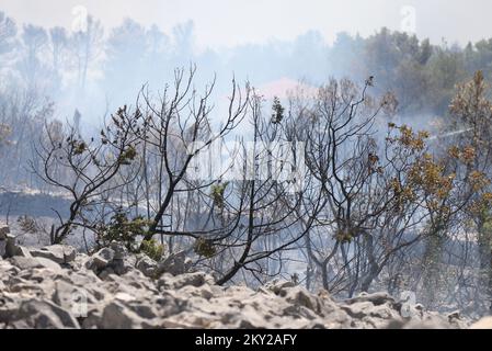 Feu dans une zone ouverte près du site archéologique Velika Mrdakovica dans l'arrière-pays de Vodice, en Croatie, sur 13 juillet 2022. Environ 30 pompiers et une douzaine de véhicules sont au sol, et deux Canadairs se sont joints aux forces terrestres pour éteindre l'incendie. Il y a des forêts de pins au-dessus, une faible végétation et des bâtiments en danger. Photo: Dusko Jaramaz/PIXSELL Banque D'Images