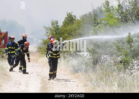 Feu dans une zone ouverte près du site archéologique Velika Mrdakovica dans l'arrière-pays de Vodice, en Croatie, sur 13 juillet 2022. Environ 30 pompiers et une douzaine de véhicules sont au sol, et deux Canadairs se sont joints aux forces terrestres pour éteindre l'incendie. Il y a des forêts de pins au-dessus, une faible végétation et des bâtiments en danger. Photo: Hrvoje Jelavic/PIXSELL Banque D'Images